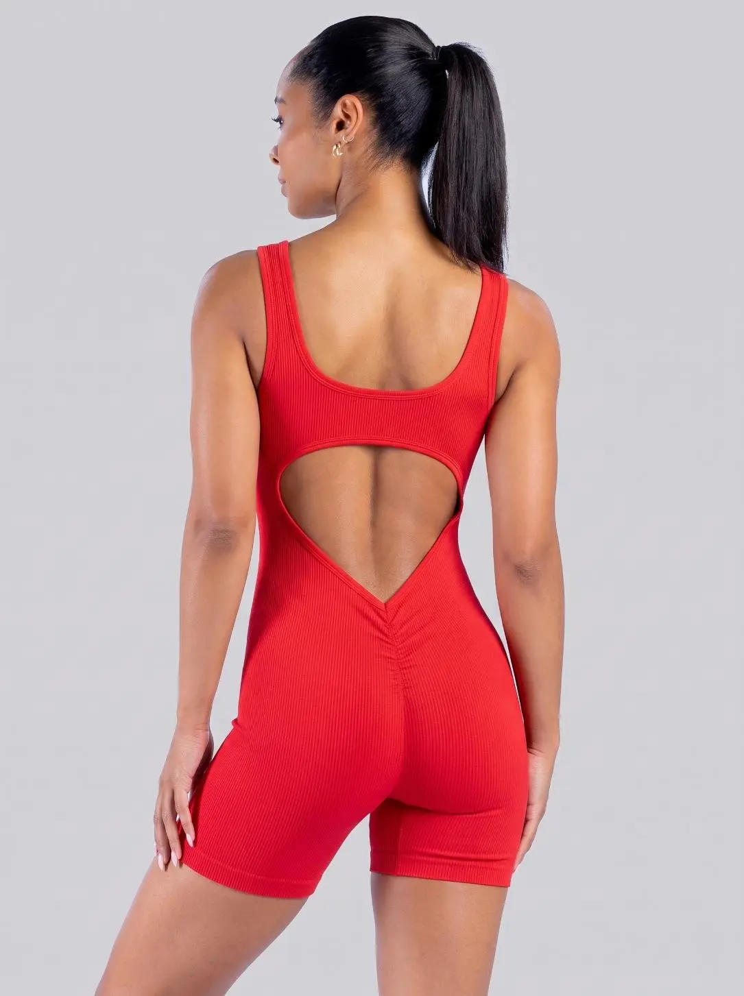 Enterizo deportivo Electra rojo sin mangas para mujer, espalda descubierta y short levanta cola